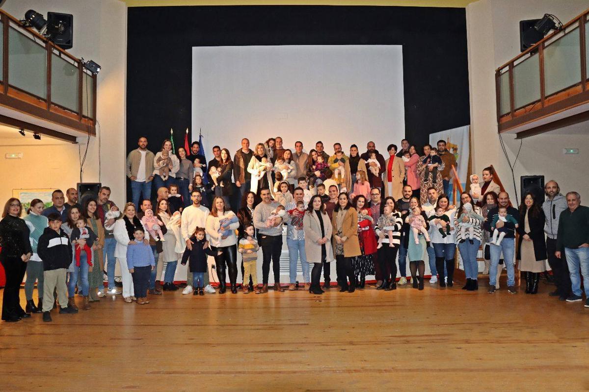 Los bebés nacidos en 2023 juntos a sus padres durante el acto.