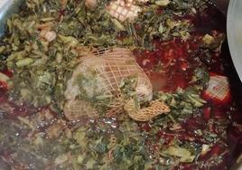 Una cazuela en la que se están cocinando las coles con buche.