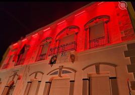 Fachada del Ayuntamiento iluminada en naranja.