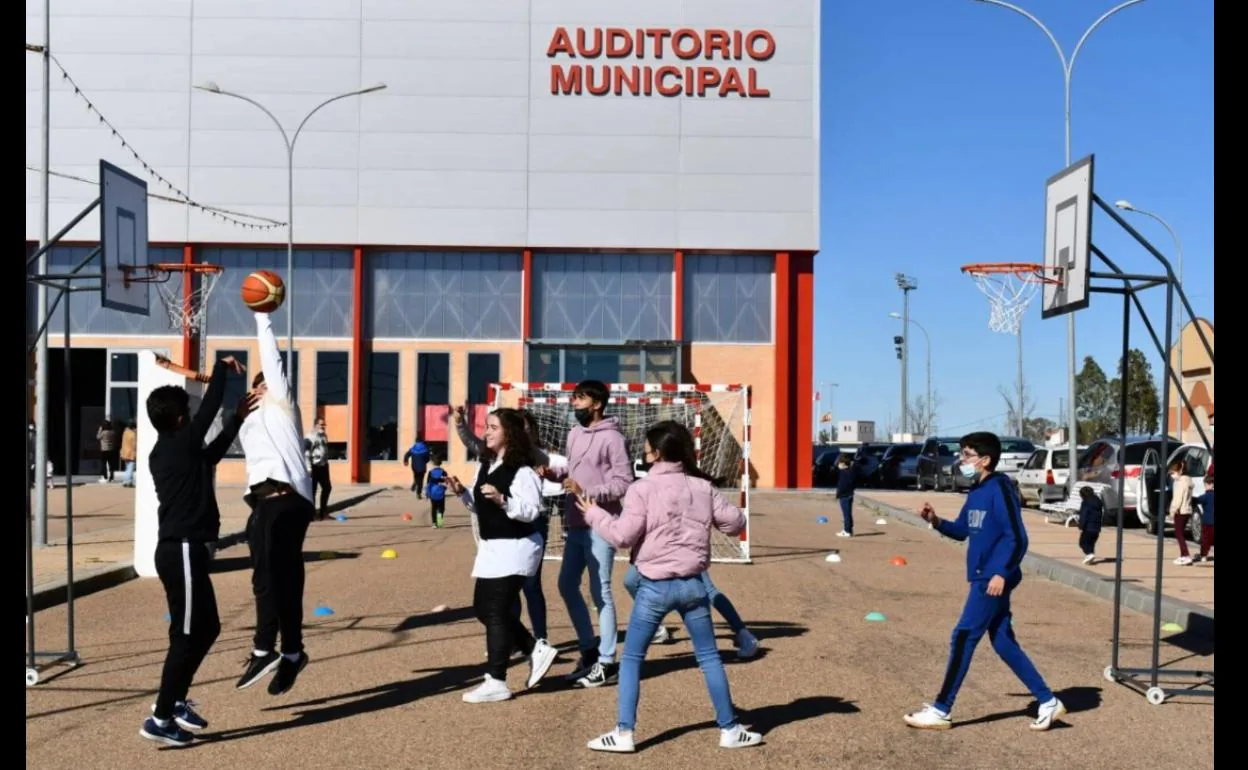Jóvenes juegan al baloncesto frente al Auditorio Municipal. 