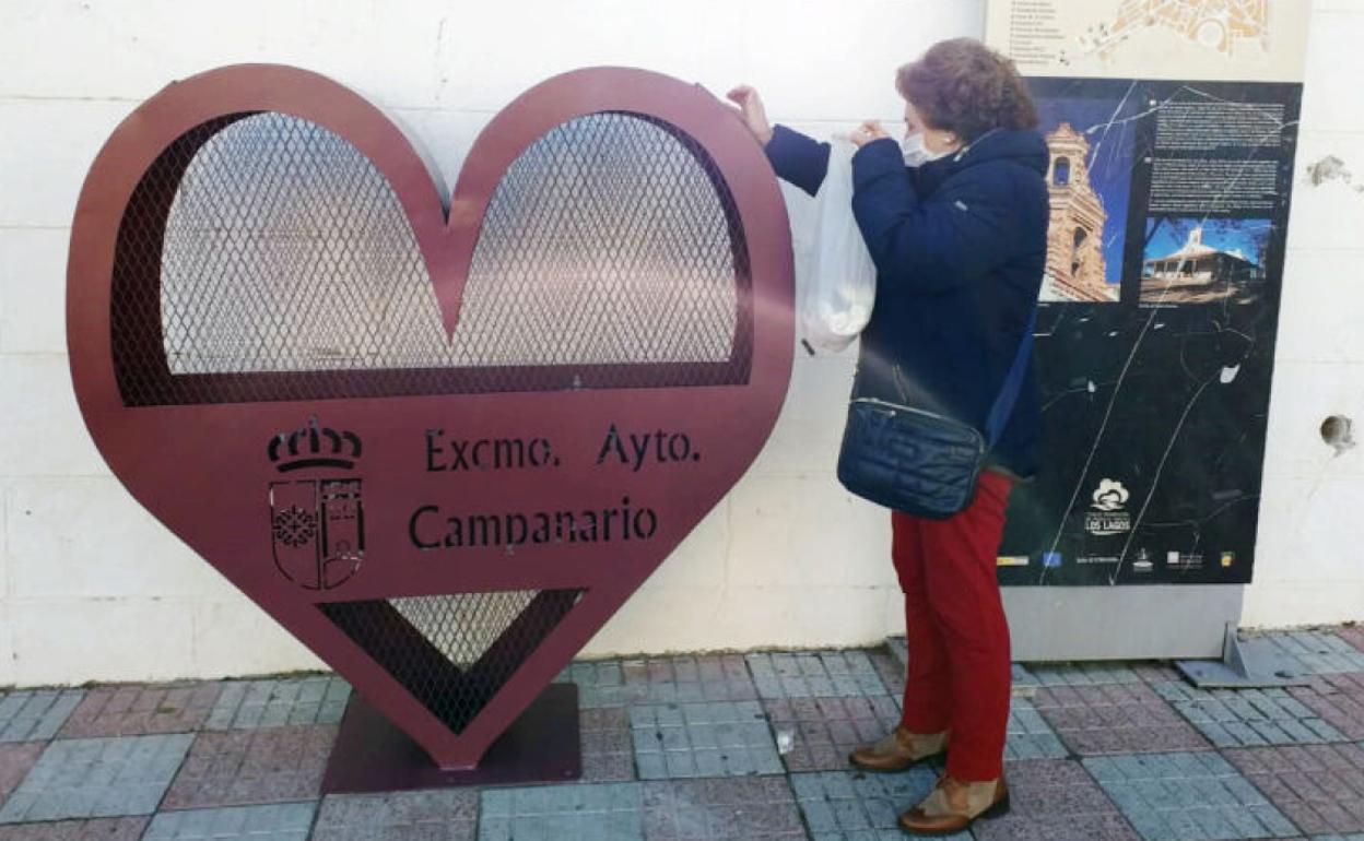 Una mujer deposita tapones en uno de los contenedores. 