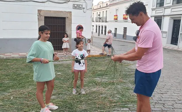 Un padre trenza el 'perigallo' para sus hijas. 