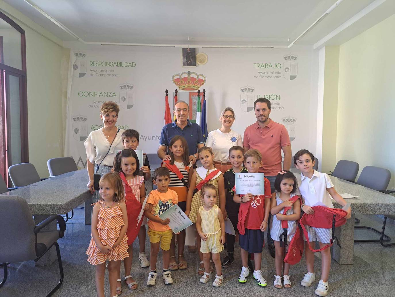 Los pequeños posan en el salón de plenos con sus diplomas junto al equipo de gobierno