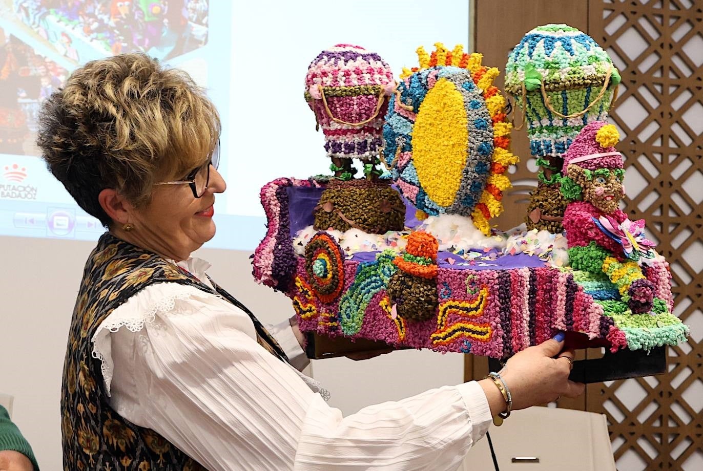 La concejala sostiene una maqueta de una carroza en representación del gran desfile del Lunes de Pascua.