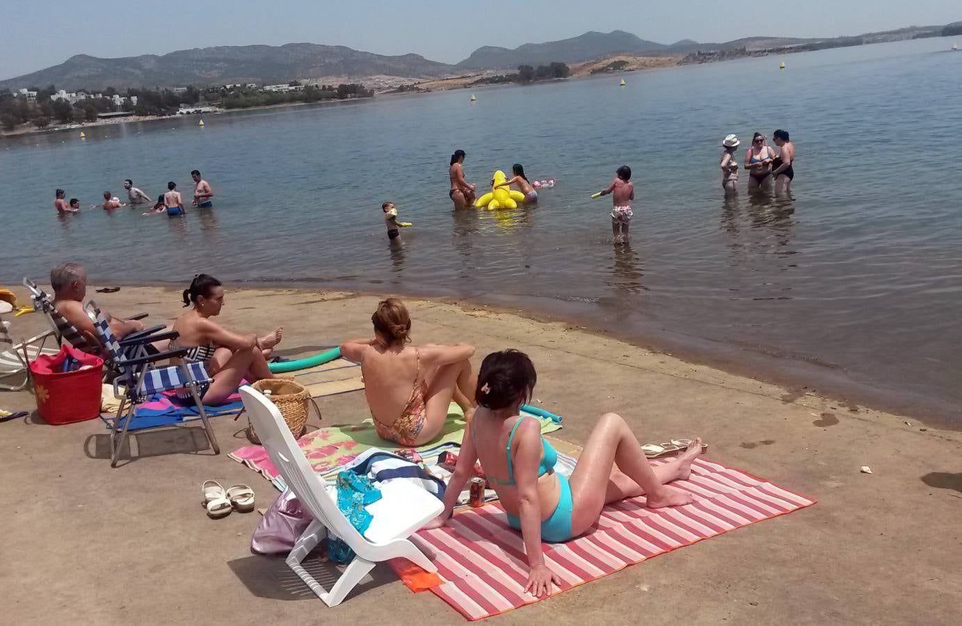Bañistas dándose un chapuzón en la playa de agua dulce de Campanario. 