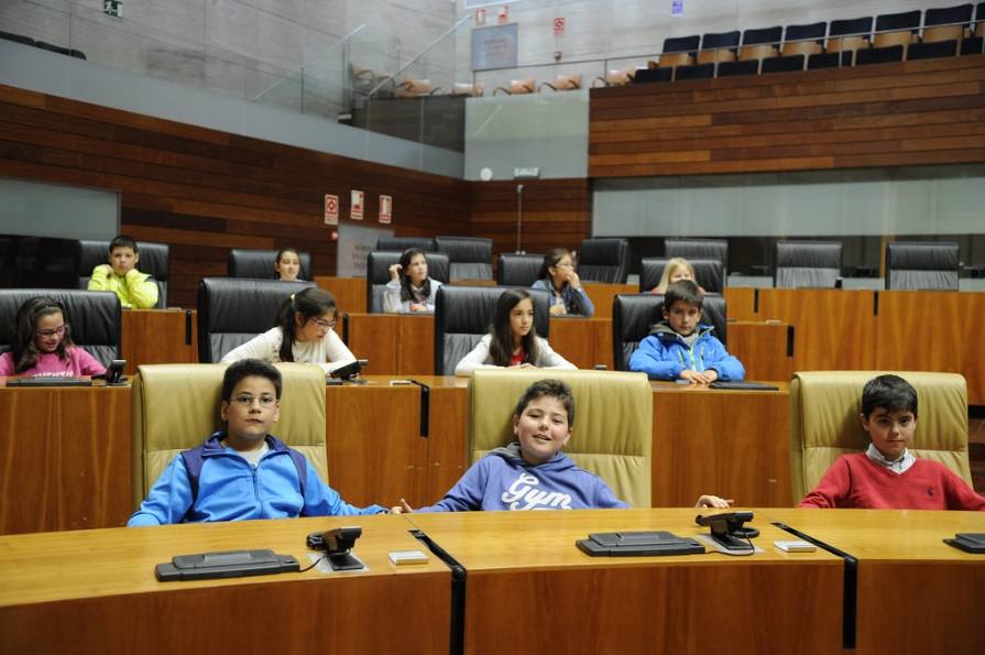 Alumnos campanarienses sentados en el hemiciclo extremeño. 