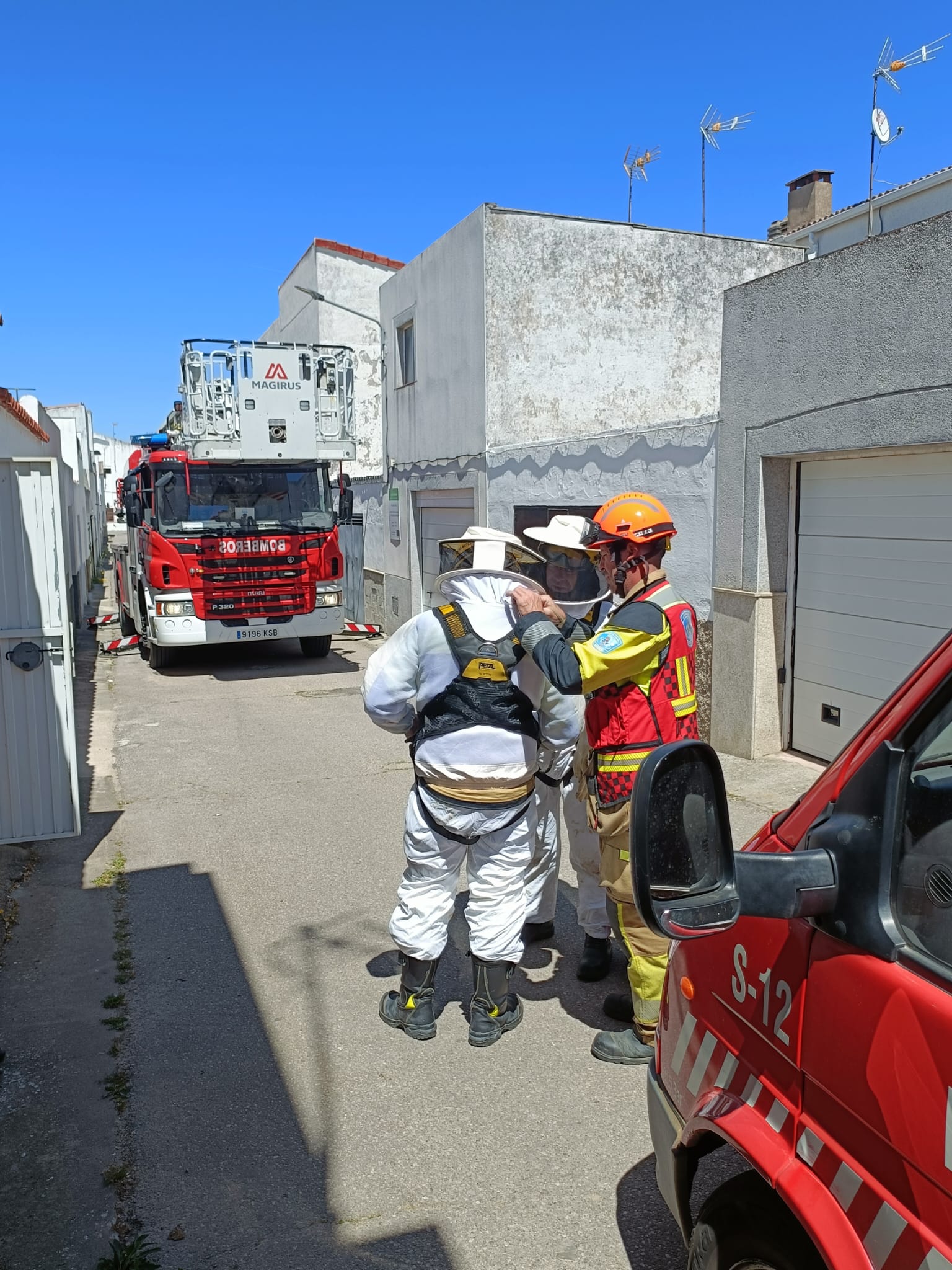Imagen principal - Intervención de los bomberos para eliminar un enjambre de abejas en la chimenea de una vivienda de la barriada Las Malvinas