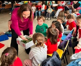 La alcaldesa muestra gusanos de seda a los más pequeños tras contarles el cuento de 'La oruga glotona'.