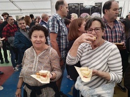 Dos casareñas disfrutan de distintas variedades de queso en la caseta municipal