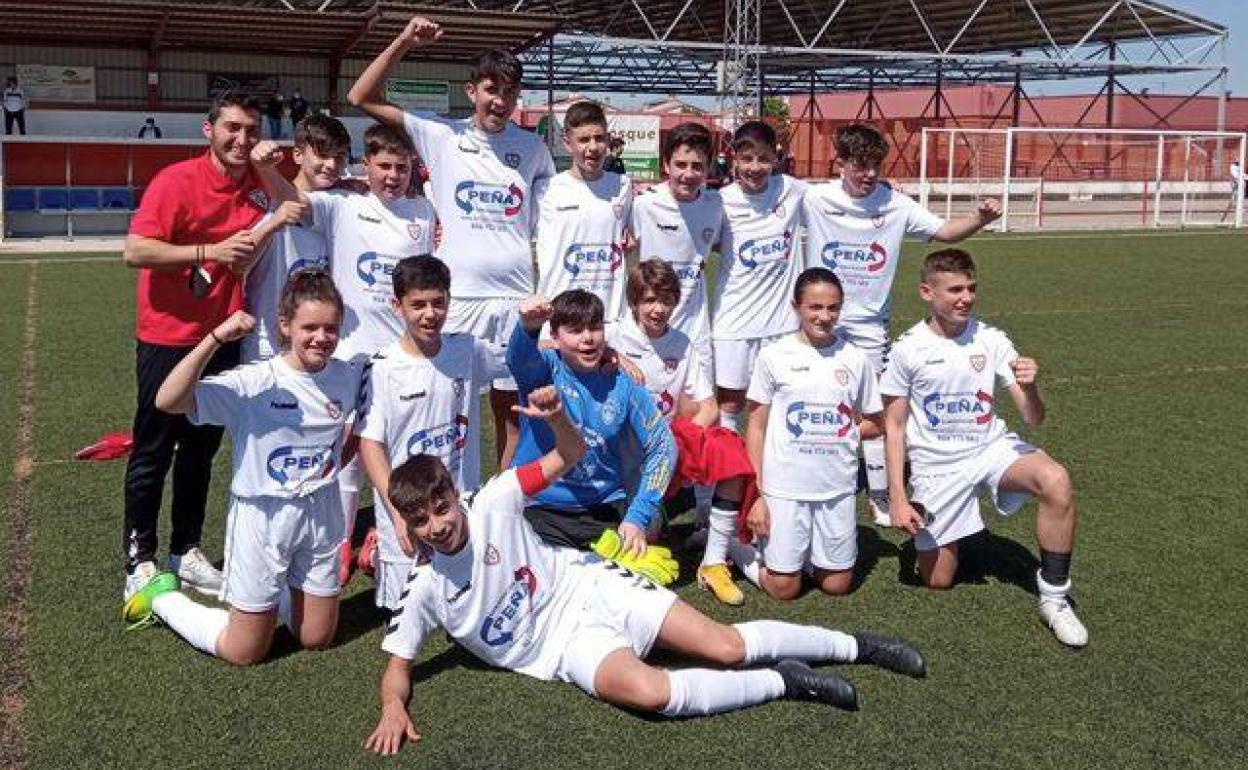 Equipo Infatil celebra el campeonato en el cesped del campo de fútbol de Casar de Cáceres. 