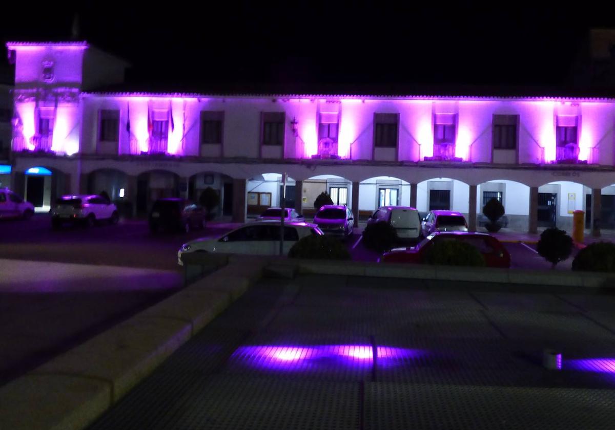 Fachada del ayuntamiento iluminada con el color violeta.