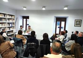 Público asistente a una presentación literaria en la biblioteca de Coria.