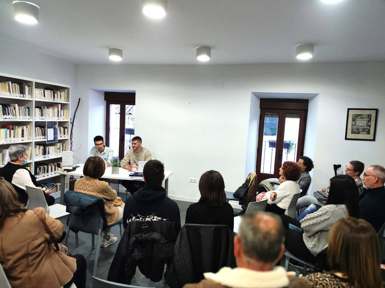 Público asistente a una presentación literaria en la biblioteca de Coria.