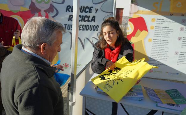 Una educadora da a un ciudadano una de las 6.000 bolsas reutilizables que ha distribuido Promedio. CEDIDA