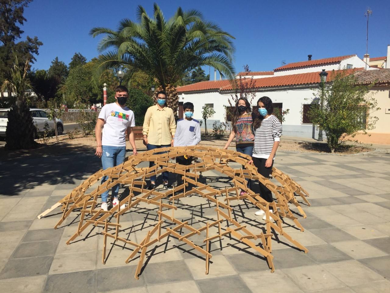 Alumnos y profesora Beatriz Blanco, segunda por la derecha, muestran la cúpula de madera en el parque Hernán Cortés de Guareña.