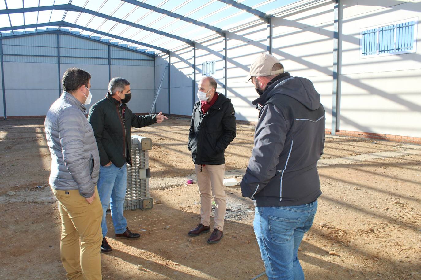 El alcalde conversa con el secretario general de población y desarrollo rural dentro de la nave AMGSA.