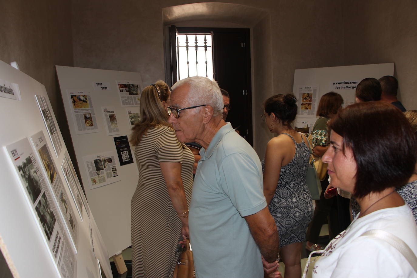 Los visitantes leyendo las noticias relacionadas con el Turuñuelo en la prensa escrita.