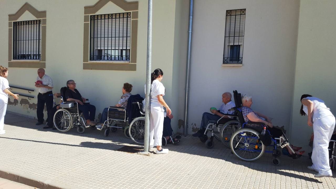 Momento de ejercicios de rehabilitación al aire libre a la sombra de la Residencia de Mayores de Guareña.