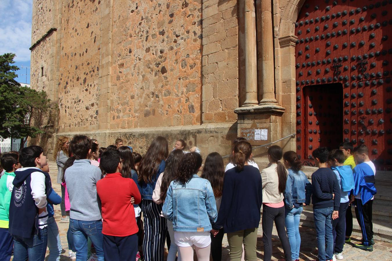 Un grupo de escolares atiende las explicaciones de la guía Sandra Hidalgo sobre la iglesia de Santa María de Guareña.