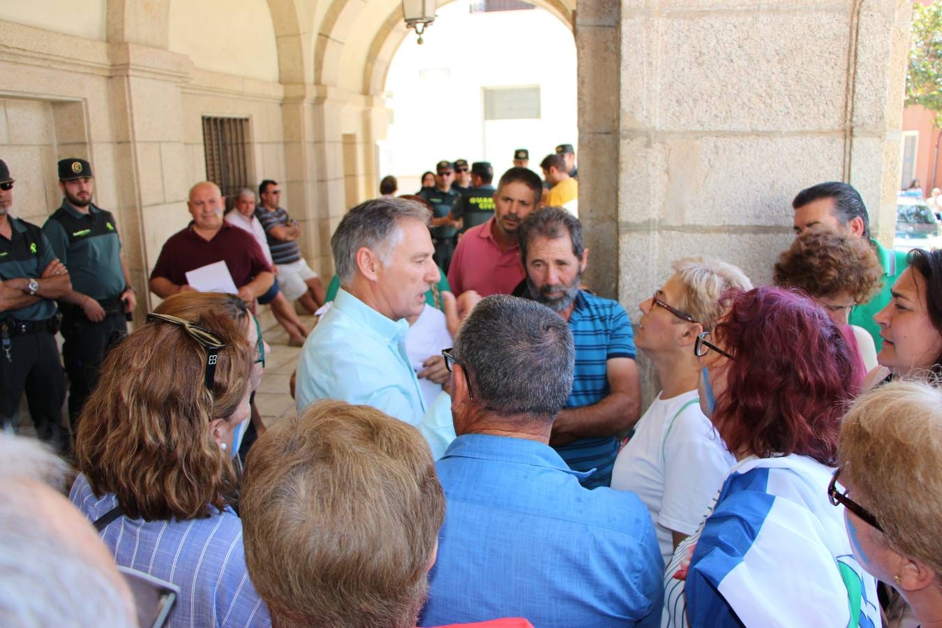El alcalde de Torrefresneda, Gaspar Morillo, habla con sus vecinos en los soportales del ayuntamiento de Guareña el pasado viernes 20 de julio.