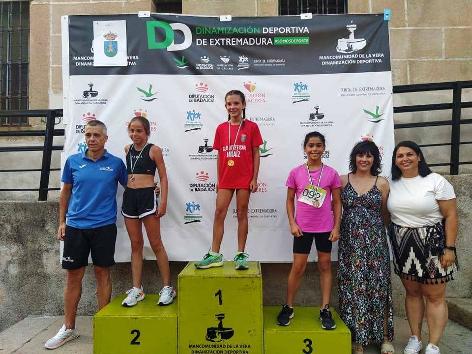 Daniella en lo alto del podio y Ahinoa, en el segundo cajón, en la entrega de premios de la carrera de Jaraíz, arropadas por Alan Otero, Miriam Bajo y Cintia Gómez.