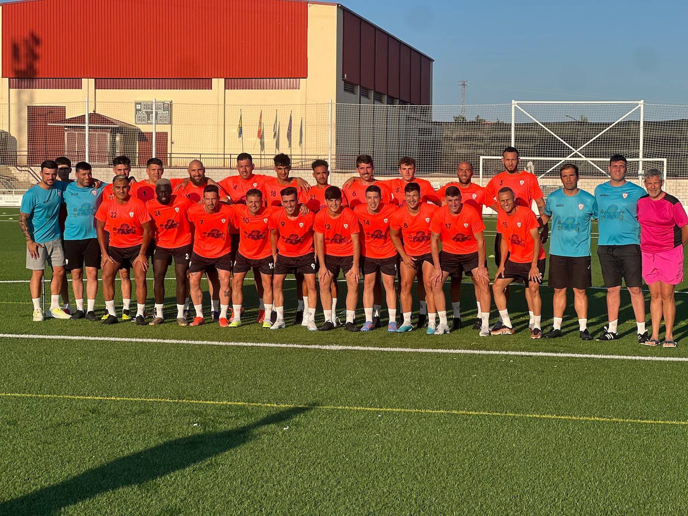 La plantilla y el cuerpo técnico en el césped del remozado polideportivo municipal.
