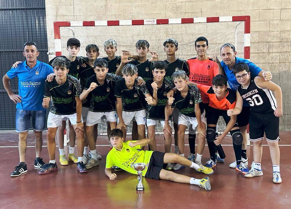 Los jugadores y técnicos con el trofeo de campeones celebran otro triunfo más este verano.