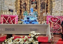 La Virgen del Salobrar en medio de los dos paneles con las flores de la ofrenda.