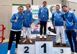 Los preparadores Moi y Dani flanqueando a los medallistas jaraiceños en lo alto del podio.