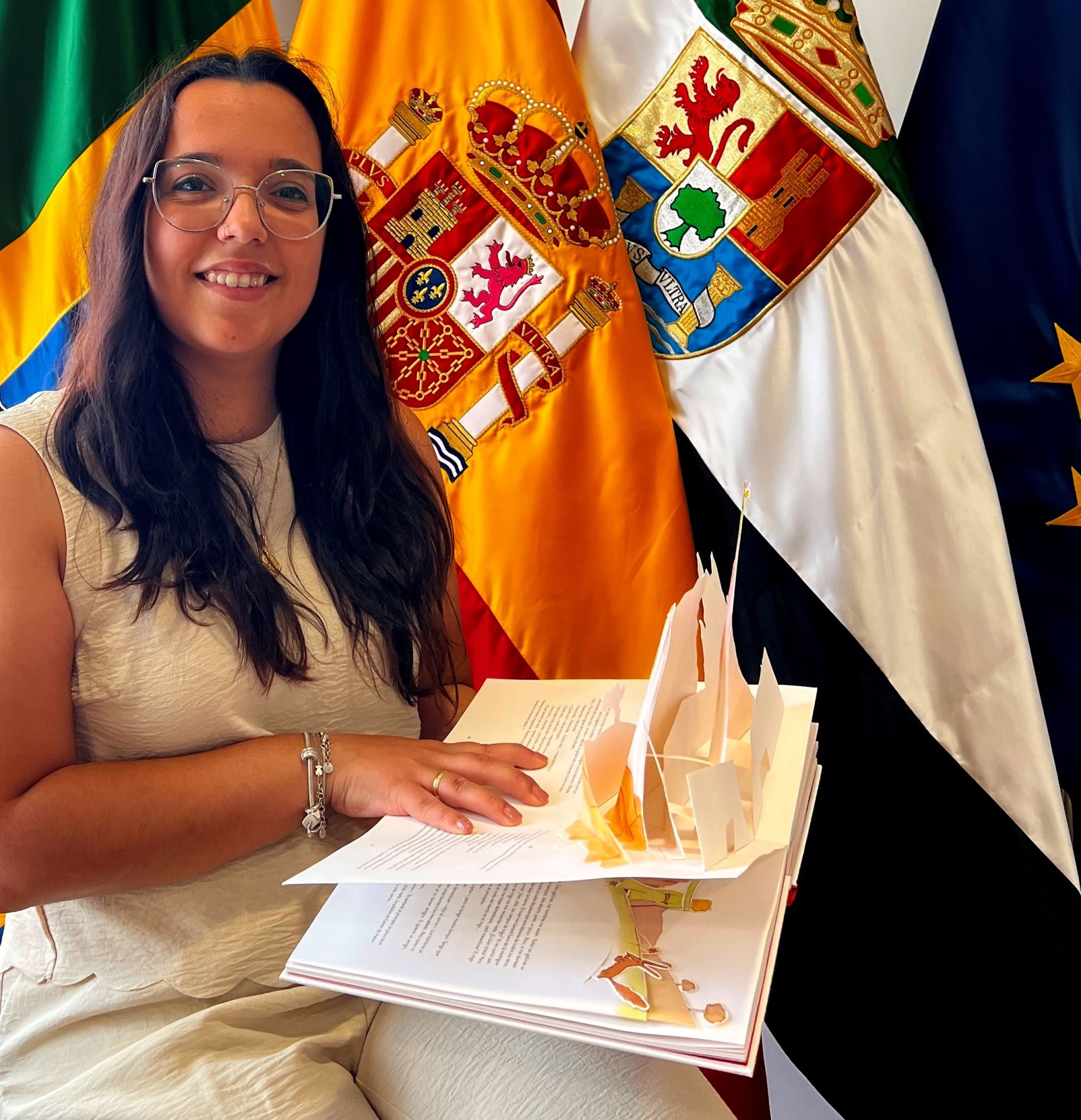 Carolina Picapiedra de Matías delante de las banderas jaraiceña, española y extremeña.