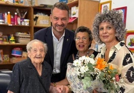 El alcalde y la concejala durante la entregan del ramo de flores.