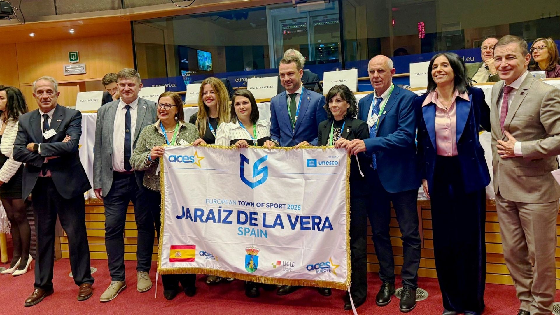 La delegación jaraiceña con la bandera acreditativa de la distinción con los miembros de ACES.