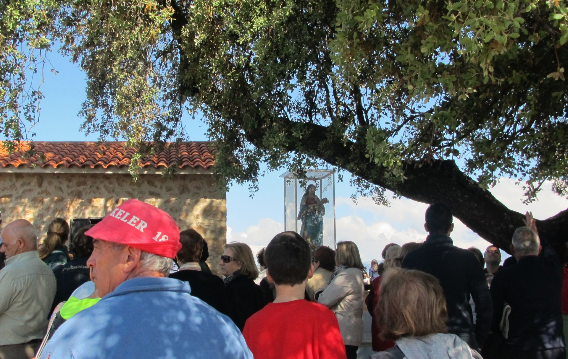La Virgen y romeros cobijándose debajo de la encina.