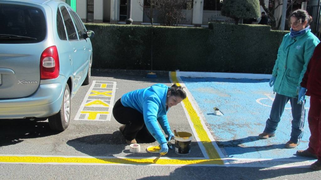 Una operaria delimita de aparcamiento. 