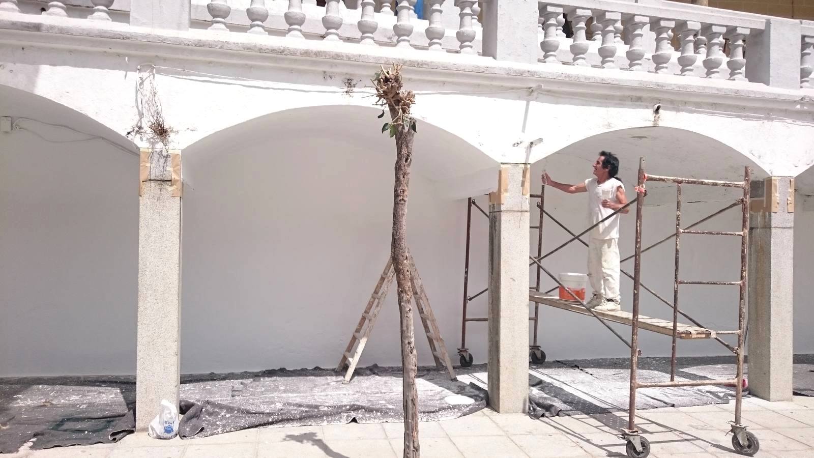Operario pintando las paredes de la Plaza Mayor.