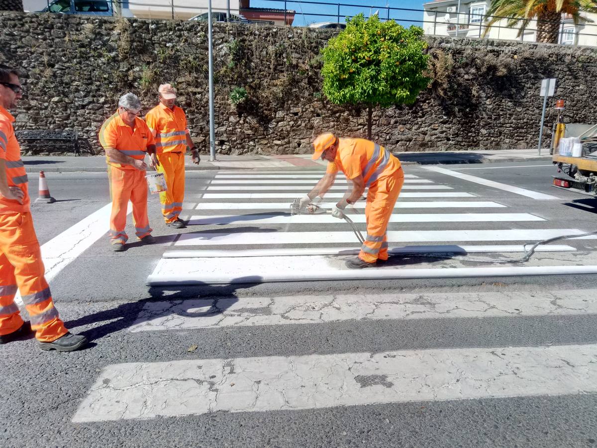 Operarios de la Junta repintando los pasos. 