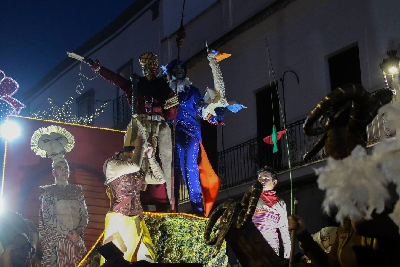 Jerez de los Caballeros se inundó de magia, ilusión y colorido con su tradicional Cabalgata de Reyes Magos. Primero, fueron los mayores de la Residencia Hernando de Soto quienes disfrutaron de la presencia de sus Majestades de Oriente junto a la visita de autoridades y miembros de las distintas cofradías y hermandades. Desde el Ayuntamiento se había dispuesto este año un recorrido distinto y el el entorno del citado centro, junto al parque de Santa Lucía, fue el punto de partida de una cabalgata que vivió uno de sus momentos más extraordinarios en la Plaza de España con mucha presencia de público. Junto a los tronos de Melchor, Gaspar y Baltasar, carrozas realizadas por el Ayuntamiento, destacó la participación de asociaciones y colectivos: vecinos de La Bazana, 'Euexia Rural', la Asociación cultural del Belén Santa Ángela y la Asociación juvenil 'La Trouppe', que con más de 100 componentes ofreció un gran espectáculo con la recreación de la fantasía de 'El Rey león'. La música acrecentó el ambiente de ilusión, con los sones de la Agrupación Musical 'Nuestro Padre Jesús Nazareno' y la Agrupación Musical 'Maestro Sousa' de la OJE. Los más pequeños vivieron la cita con emoción y fueron los verdaderos protagonistas del mejor prólogo de una de las noches más especiales del año.Además del amplio despliegue de fantasía y colorido, estuvo la labor de: Policía Local, Cruz Roja, Protección Civil, Bomberos, Guardia Civil, para el buen desarrollo de este evento.