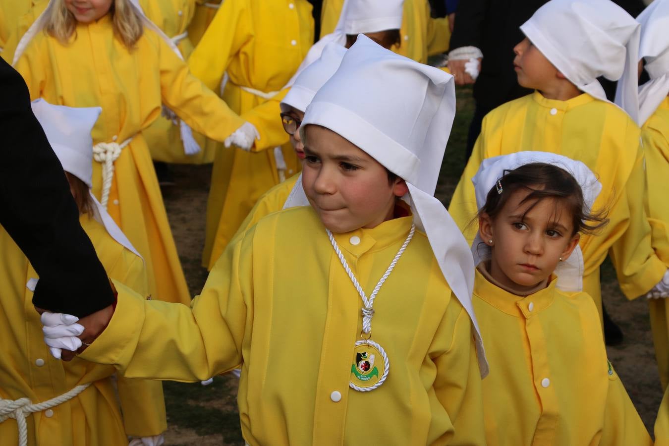 El Colegio «El Rodeo» celebró, ayer, una nueva edición de su Semana Santa infantil que, año tras año, se consolida como una de las citas imprescindibles del calendario cofrade jerezano. La iniciativa cuenta con la implicación de alumnos, padres y profesores, y muestra cómo los más pequeños comienzan a interiorizar los roles propios de quienes participan y hacen posible la Semana Santa del municipio: costaleros, capataces, nazarenos, agrupaciones musicales, mujeres ataviadas con mantilla negra, escoltas romanas, etc. La Agrupación Musical «Nuestro Padre Jesús Nazareno» y la Agrupación Musical «Maestro Sousa» de la OJE acompañaron con sus sones esta entrañable recreación.