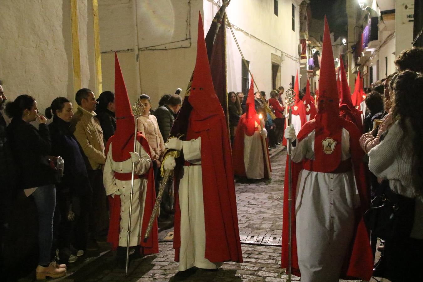 La vista al cielo se convertía, ayer, en una de las prácticas más repetida por los jerezanos. La lluvia amenazaba con marcar un antes y después en la Semana Santa jerezana 2019, Fiesta de Interés Turístico Nacional, e impedir la salida de la Cofradía del Señor 'Ecce-Homo', protagonista del Miércoles Santo. Una leve llovizna que, comenzaría a principio de la tarde, se convirtió en persistente a medida que pasaban las horas. Razón por la que la Cofradía decidió retrasar su hora de salida hasta pasadas las 21:30 horas, cuando la puerta del Perdón de San Miguel Arcángel se abría para iniciar el desfile procesional. Un desfile procesional que se vio interrumpido, de nuevo, por la lluvia, obligando al Señor 'Ecce-Homo' y Nuestra Señora de los Desamparados a regresar al templo. 