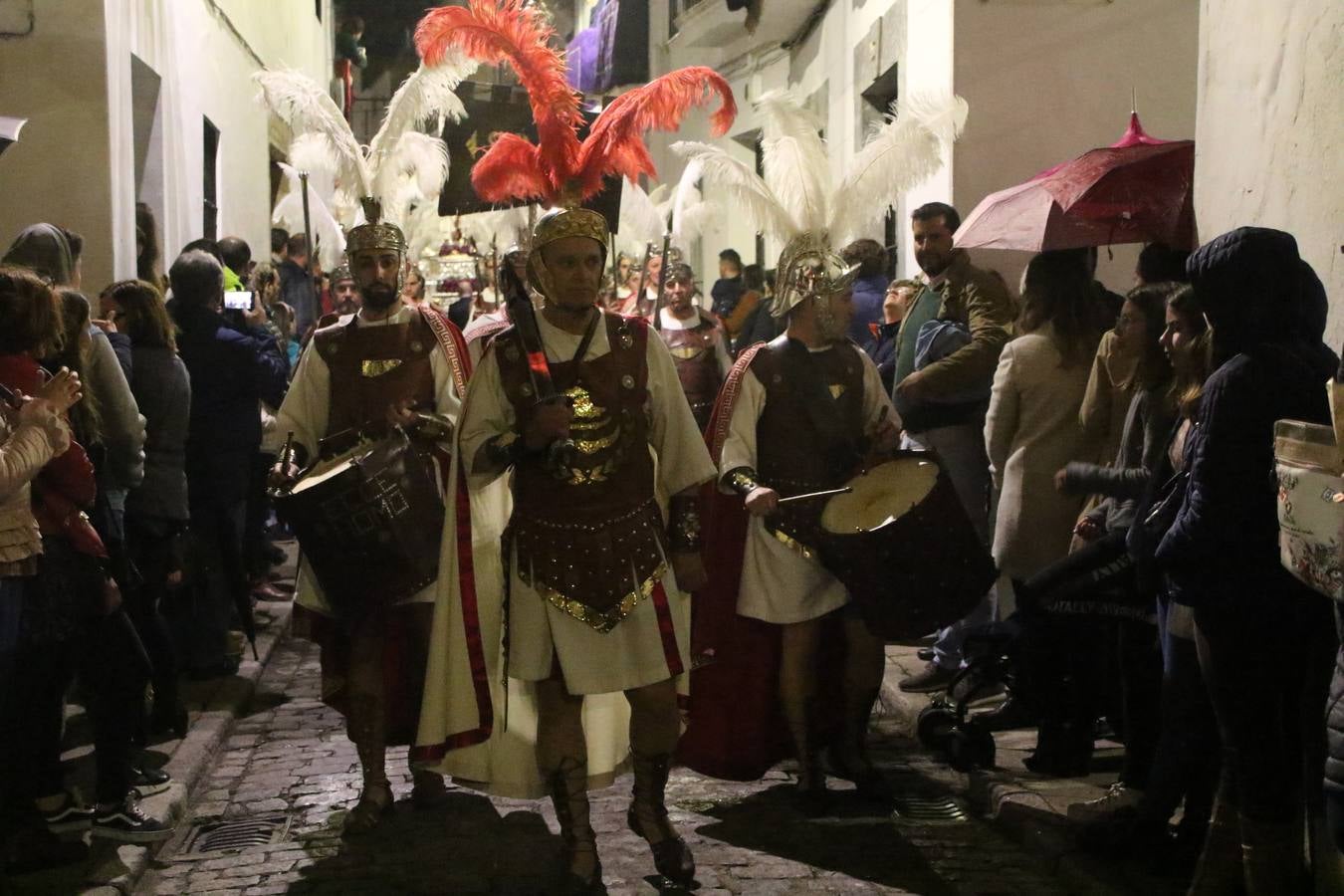 La vista al cielo se convertía, ayer, en una de las prácticas más repetida por los jerezanos. La lluvia amenazaba con marcar un antes y después en la Semana Santa jerezana 2019, Fiesta de Interés Turístico Nacional, e impedir la salida de la Cofradía del Señor 'Ecce-Homo', protagonista del Miércoles Santo. Una leve llovizna que, comenzaría a principio de la tarde, se convirtió en persistente a medida que pasaban las horas. Razón por la que la Cofradía decidió retrasar su hora de salida hasta pasadas las 21:30 horas, cuando la puerta del Perdón de San Miguel Arcángel se abría para iniciar el desfile procesional. Un desfile procesional que se vio interrumpido, de nuevo, por la lluvia, obligando al Señor 'Ecce-Homo' y Nuestra Señora de los Desamparados a regresar al templo. 