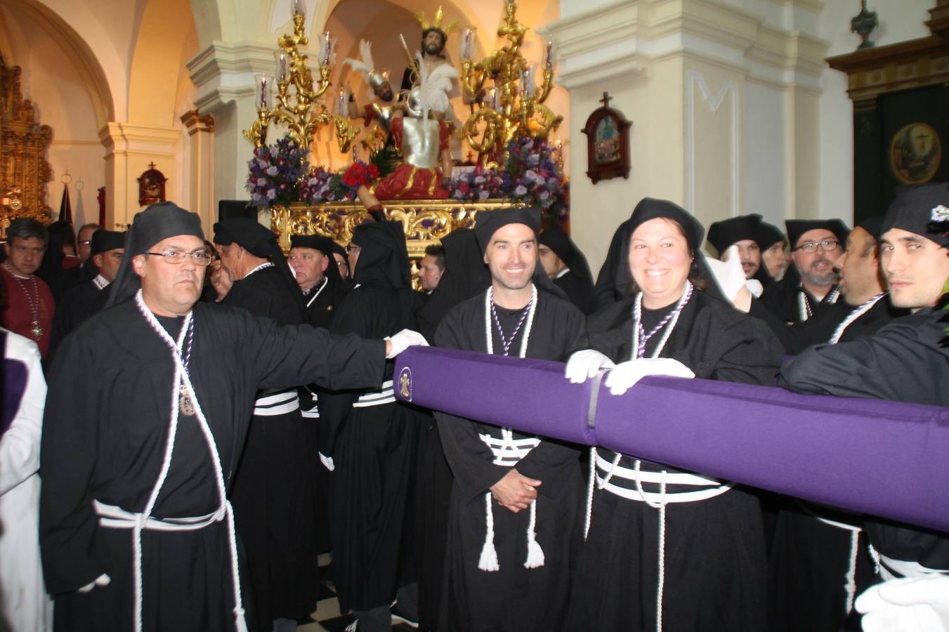 Las emociones llenaron también anoche la ermita de Los Santos Mártires, donde se quedaron guardados todos los afanes, las ilusiones y la devoción que no pudieron tener reflejo en la procesión de las colas largas, La Cofradía del Señor Coronado de Espinas decidió no salir ante la adversidad de la climatología y en el interior de este pequeño templo se vivieron momentos de gran emotividad.La Guardia Civil de Jerez de los Caballeros rindió honores a s Madrina, María Santísima de la Amargura. Los sones de las bandas y agrupaciones que iban a participar en el desfile procesional expandieron su eco desde el Llano de los Mártires para acompañar a los costaleros de cada uno de los tres Pasos, que fueron mecidos a su compás. El jovencísimo saetero Julián Jaramillo, de tan solo 12 años y natural de Segura de León, hizo vibrar a los presentes con su saeta al Coronado.Y entre las oraciones del párroco, Antonio María Rejano y los sacerdotes que le acompañaron, asomaron también las lágrimas.El momento más emotivo se vivió con el sentido homenaje a Manuel Labrador González, Manolo 'Cornelio' a quien Marisa Sánchez, en nombre de la junta de gobierno de la Cofradía del Señor Coronado, dedicó palabras llenas de afecto y reconocimiento, destacando su condición de «trabajador sin igual», su carácter innovador, su generosidad, sus consejos a jóvenes y mayores en el seno de esta Cofradía de la que dijo, «es piedra angular» y su extraordinaria labor. Manuel recibió un libro y una precioso cartel realizada por José Tomás Pérez Indiano, a semejanza del que hace tres años anunció la Semana Santa Jerezana. Emocionado, Manuel agradeció el cariño y dedicó este homenaje a su familia y a todas las madres.