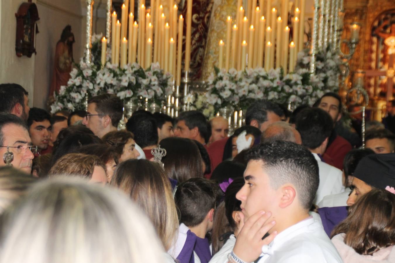 Las emociones llenaron también anoche la ermita de Los Santos Mártires, donde se quedaron guardados todos los afanes, las ilusiones y la devoción que no pudieron tener reflejo en la procesión de las colas largas, La Cofradía del Señor Coronado de Espinas decidió no salir ante la adversidad de la climatología y en el interior de este pequeño templo se vivieron momentos de gran emotividad.La Guardia Civil de Jerez de los Caballeros rindió honores a s Madrina, María Santísima de la Amargura. Los sones de las bandas y agrupaciones que iban a participar en el desfile procesional expandieron su eco desde el Llano de los Mártires para acompañar a los costaleros de cada uno de los tres Pasos, que fueron mecidos a su compás. El jovencísimo saetero Julián Jaramillo, de tan solo 12 años y natural de Segura de León, hizo vibrar a los presentes con su saeta al Coronado.Y entre las oraciones del párroco, Antonio María Rejano y los sacerdotes que le acompañaron, asomaron también las lágrimas.El momento más emotivo se vivió con el sentido homenaje a Manuel Labrador González, Manolo 'Cornelio' a quien Marisa Sánchez, en nombre de la junta de gobierno de la Cofradía del Señor Coronado, dedicó palabras llenas de afecto y reconocimiento, destacando su condición de «trabajador sin igual», su carácter innovador, su generosidad, sus consejos a jóvenes y mayores en el seno de esta Cofradía de la que dijo, «es piedra angular» y su extraordinaria labor. Manuel recibió un libro y una precioso cartel realizada por José Tomás Pérez Indiano, a semejanza del que hace tres años anunció la Semana Santa Jerezana. Emocionado, Manuel agradeció el cariño y dedicó este homenaje a su familia y a todas las madres.