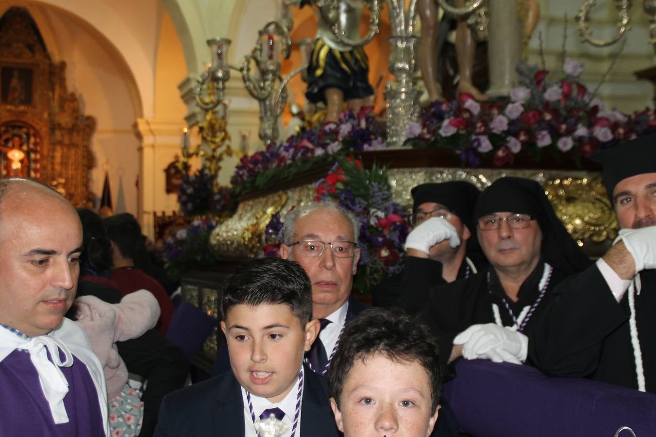 Las emociones llenaron también anoche la ermita de Los Santos Mártires, donde se quedaron guardados todos los afanes, las ilusiones y la devoción que no pudieron tener reflejo en la procesión de las colas largas, La Cofradía del Señor Coronado de Espinas decidió no salir ante la adversidad de la climatología y en el interior de este pequeño templo se vivieron momentos de gran emotividad.La Guardia Civil de Jerez de los Caballeros rindió honores a s Madrina, María Santísima de la Amargura. Los sones de las bandas y agrupaciones que iban a participar en el desfile procesional expandieron su eco desde el Llano de los Mártires para acompañar a los costaleros de cada uno de los tres Pasos, que fueron mecidos a su compás. El jovencísimo saetero Julián Jaramillo, de tan solo 12 años y natural de Segura de León, hizo vibrar a los presentes con su saeta al Coronado.Y entre las oraciones del párroco, Antonio María Rejano y los sacerdotes que le acompañaron, asomaron también las lágrimas.El momento más emotivo se vivió con el sentido homenaje a Manuel Labrador González, Manolo 'Cornelio' a quien Marisa Sánchez, en nombre de la junta de gobierno de la Cofradía del Señor Coronado, dedicó palabras llenas de afecto y reconocimiento, destacando su condición de «trabajador sin igual», su carácter innovador, su generosidad, sus consejos a jóvenes y mayores en el seno de esta Cofradía de la que dijo, «es piedra angular» y su extraordinaria labor. Manuel recibió un libro y una precioso cartel realizada por José Tomás Pérez Indiano, a semejanza del que hace tres años anunció la Semana Santa Jerezana. Emocionado, Manuel agradeció el cariño y dedicó este homenaje a su familia y a todas las madres.