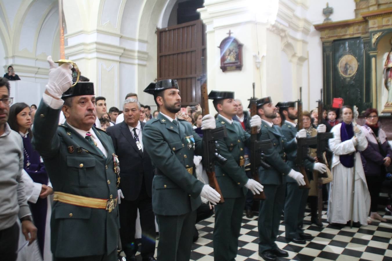 Las emociones llenaron también anoche la ermita de Los Santos Mártires, donde se quedaron guardados todos los afanes, las ilusiones y la devoción que no pudieron tener reflejo en la procesión de las colas largas, La Cofradía del Señor Coronado de Espinas decidió no salir ante la adversidad de la climatología y en el interior de este pequeño templo se vivieron momentos de gran emotividad.La Guardia Civil de Jerez de los Caballeros rindió honores a s Madrina, María Santísima de la Amargura. Los sones de las bandas y agrupaciones que iban a participar en el desfile procesional expandieron su eco desde el Llano de los Mártires para acompañar a los costaleros de cada uno de los tres Pasos, que fueron mecidos a su compás. El jovencísimo saetero Julián Jaramillo, de tan solo 12 años y natural de Segura de León, hizo vibrar a los presentes con su saeta al Coronado.Y entre las oraciones del párroco, Antonio María Rejano y los sacerdotes que le acompañaron, asomaron también las lágrimas.El momento más emotivo se vivió con el sentido homenaje a Manuel Labrador González, Manolo 'Cornelio' a quien Marisa Sánchez, en nombre de la junta de gobierno de la Cofradía del Señor Coronado, dedicó palabras llenas de afecto y reconocimiento, destacando su condición de «trabajador sin igual», su carácter innovador, su generosidad, sus consejos a jóvenes y mayores en el seno de esta Cofradía de la que dijo, «es piedra angular» y su extraordinaria labor. Manuel recibió un libro y una precioso cartel realizada por José Tomás Pérez Indiano, a semejanza del que hace tres años anunció la Semana Santa Jerezana. Emocionado, Manuel agradeció el cariño y dedicó este homenaje a su familia y a todas las madres.