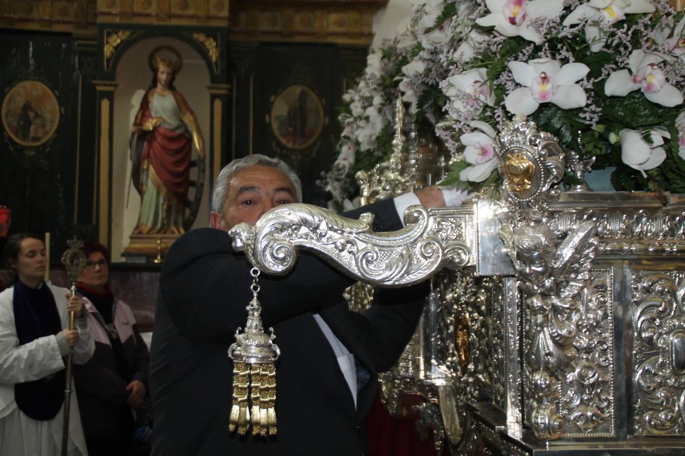 Las emociones llenaron también anoche la ermita de Los Santos Mártires, donde se quedaron guardados todos los afanes, las ilusiones y la devoción que no pudieron tener reflejo en la procesión de las colas largas, La Cofradía del Señor Coronado de Espinas decidió no salir ante la adversidad de la climatología y en el interior de este pequeño templo se vivieron momentos de gran emotividad.La Guardia Civil de Jerez de los Caballeros rindió honores a s Madrina, María Santísima de la Amargura. Los sones de las bandas y agrupaciones que iban a participar en el desfile procesional expandieron su eco desde el Llano de los Mártires para acompañar a los costaleros de cada uno de los tres Pasos, que fueron mecidos a su compás. El jovencísimo saetero Julián Jaramillo, de tan solo 12 años y natural de Segura de León, hizo vibrar a los presentes con su saeta al Coronado.Y entre las oraciones del párroco, Antonio María Rejano y los sacerdotes que le acompañaron, asomaron también las lágrimas.El momento más emotivo se vivió con el sentido homenaje a Manuel Labrador González, Manolo 'Cornelio' a quien Marisa Sánchez, en nombre de la junta de gobierno de la Cofradía del Señor Coronado, dedicó palabras llenas de afecto y reconocimiento, destacando su condición de «trabajador sin igual», su carácter innovador, su generosidad, sus consejos a jóvenes y mayores en el seno de esta Cofradía de la que dijo, «es piedra angular» y su extraordinaria labor. Manuel recibió un libro y una precioso cartel realizada por José Tomás Pérez Indiano, a semejanza del que hace tres años anunció la Semana Santa Jerezana. Emocionado, Manuel agradeció el cariño y dedicó este homenaje a su familia y a todas las madres.