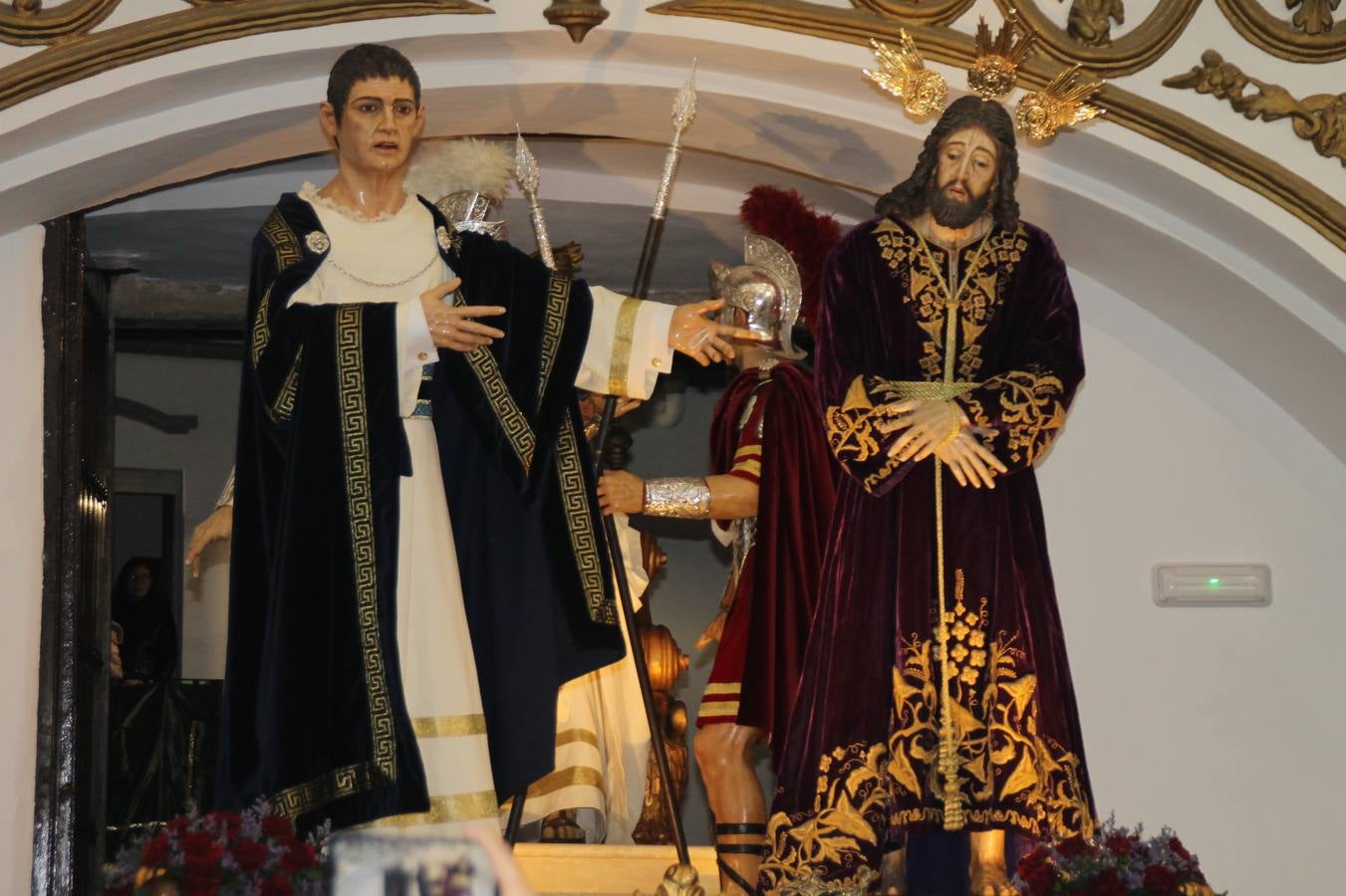 La lluvia que durante las primeras horas de la tarde se contuvo, hizo acto de presencia nada más asomarse a la calle la procesión de las túnicas celestes, que organiza la Archicofrafía del Santísimo Sacramento. Todas las emociones se vieron frustradas y el templo de San Bartolomé fue refugio para el sentimiento de quienes anhelaban acompañar esta estación de penitencia en la que se representa el momento de la institución de la Santa Cena, que junto al de Jesús ante Pilatos, fueron los únicos que realizaron su salida de la iglesia patronal. El Cristo de la Piedad, imagen impresionante en el itinerario de la Semana Santa jerezana, y la hermosa Virgen de la Paza, se quedaron dentro.Los sones de las Agruaciones y bandas que iban a acompañar este desfile sonaron especiales para bailar estas dos imágenes y servir de consuelo, mientras brotaban lágrimas en los ojos de algunos niños que encuentran en esta Cofradía su bautismo nazareno. La oración también acompañó estos momentos de tristeza al tiempo tan especiales.