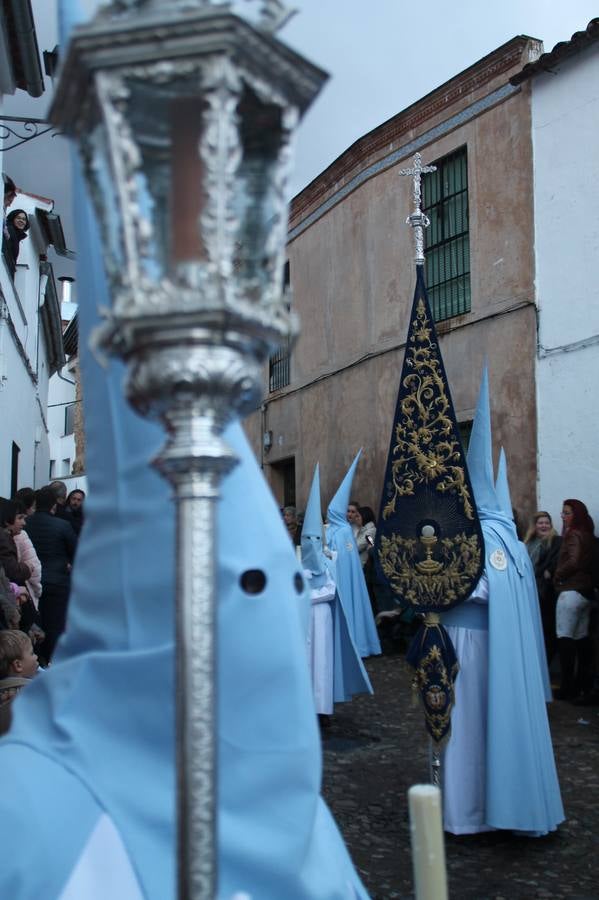 La lluvia que durante las primeras horas de la tarde se contuvo, hizo acto de presencia nada más asomarse a la calle la procesión de las túnicas celestes, que organiza la Archicofrafía del Santísimo Sacramento. Todas las emociones se vieron frustradas y el templo de San Bartolomé fue refugio para el sentimiento de quienes anhelaban acompañar esta estación de penitencia en la que se representa el momento de la institución de la Santa Cena, que junto al de Jesús ante Pilatos, fueron los únicos que realizaron su salida de la iglesia patronal. El Cristo de la Piedad, imagen impresionante en el itinerario de la Semana Santa jerezana, y la hermosa Virgen de la Paza, se quedaron dentro.Los sones de las Agruaciones y bandas que iban a acompañar este desfile sonaron especiales para bailar estas dos imágenes y servir de consuelo, mientras brotaban lágrimas en los ojos de algunos niños que encuentran en esta Cofradía su bautismo nazareno. La oración también acompañó estos momentos de tristeza al tiempo tan especiales.