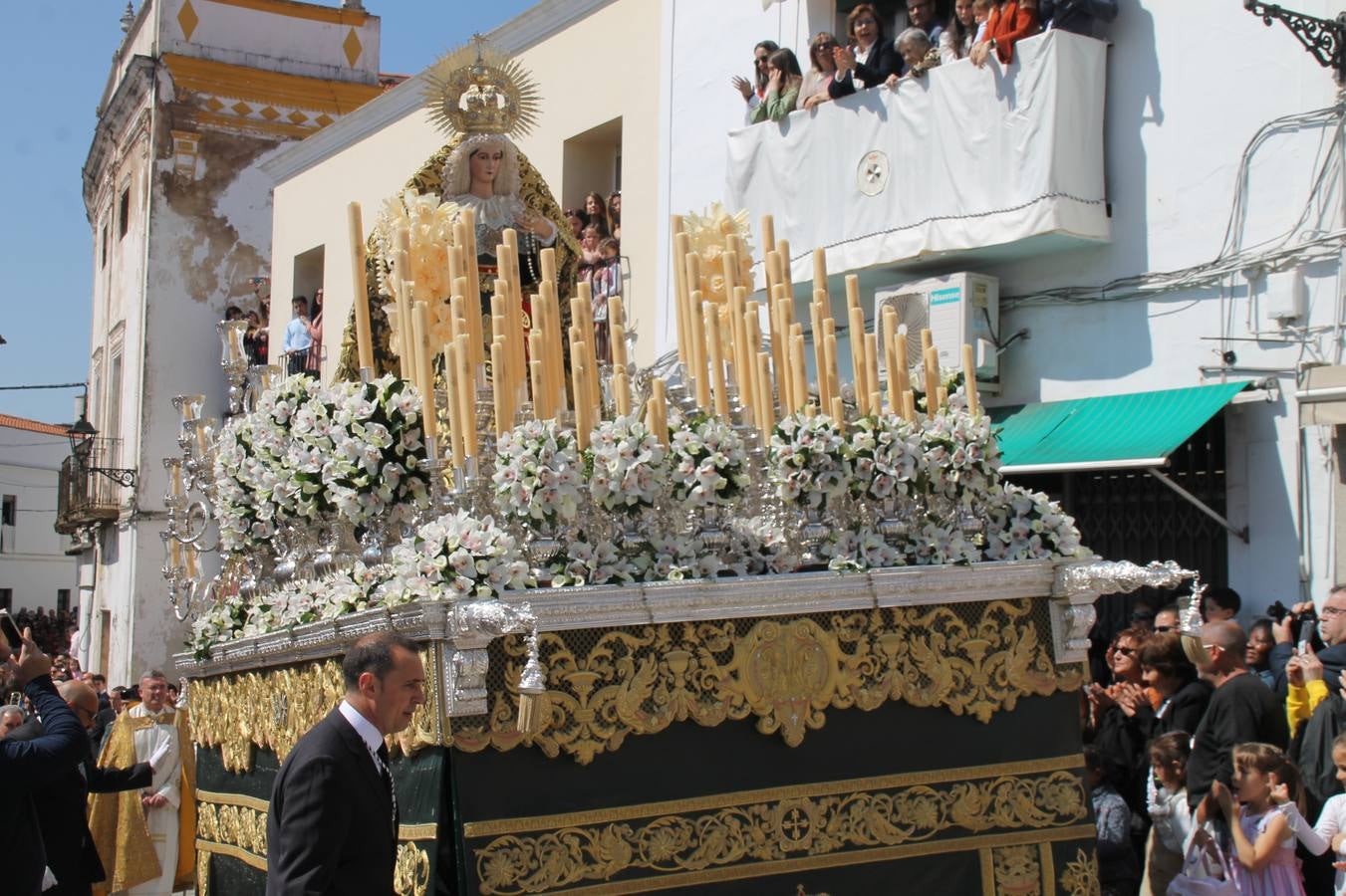 La luz y el gozo han puesto un gran broche a una Semana Santa, aciaga en sus momentos más intensos, a causa del mal tiempo que desde la noche del Miércoles y hasta el Viernes Santo trastocó en buena medida su desarrollo.Hoy el sol ha lucido en el cielo que como, cada Domingo de Resurrección, ha servido de Palio al hermoso Paso de la Virgen del Rosario, haciendo resplandecer, al tiempo, el momento culmen de esta celebración, el reencuentro en la Madre y el Hijo en la Fuente de los Santos, abarrotada de público. El momento ha sido emocionante, con los costaleros de la virgen y del Paso del Resucitado subiendo los brazos al cielo para representar el abrazo de ambas imágenes, ante la tradicional suelta de globos de ecolores y el estrépito de cornetas y tambores.La procesión ha seguido su curso hacia la Plaza de España, también muy concurrida, siendo en este escenario donde, miembros de Grupo Joven de la Cofradía del Coronado han regalado una petalada a la Virgen del Rosario. Ha sido un ofecimiento de la citada Cofradía que la noche del pasado Jueves no pudo obsequiar a su Virgen de la Amargura con esta lluvia de pétalos de rosas, a causa del mal tiempo.Así ha terminado la Semana Santa, incompleta para varias cofradías. La parte más amarga la han vivido la Cofradía del Señor Ecce-Homo que vió acortado su recorrido el Miércoles en una noche desapacible. También la Archicofradía del Santísimo Sacramento que apenas pudo asomarse a la calle y vió concentradas sus emociones en el templo patronal y la Cofradía del Señor Coronado de Espinas que también concentró el sentimieno y la devoción en la ermita de los Santos Mártires, viviendo momenos íntimos de gran emotividad. La Hermandad de la Esperanza Macarena brilló, sin embargo, en la Madrugá jerezana y la Cofradía de Nuestro Padre Jesús Nazareno derrochó fervor la tarde del Viernes en el interior de la iglesia visigoda de Santa María.