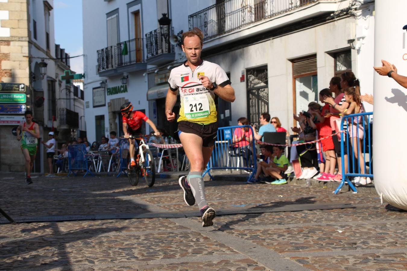 La Plaza de España de Jerez de los Caballeros acogió, ayer, la XXI Carrera Popular y VIII Caminata por la Salud y Solidaridad, organizada por la Concejalía de Juventud y Deportes del Ayuntamiento de Jerez con el apoyo del Programa de Dinamización Deportiva de la Mancomunidad Sierra Suroeste. Esta edición congregó a más de 250 participantes entre todas las categorías y se recaudaron 84 kilos de alimentos y 75 euros destinados a Cruz Roja en Jerez. La citada prueba se consagra, año tras año, como una de las citas deportivas ineludibles y más esperadas por los jerezanos y jerezanas. 