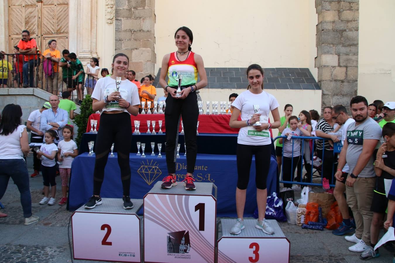La Plaza de España de Jerez de los Caballeros acogió, ayer, la XXI Carrera Popular y VIII Caminata por la Salud y Solidaridad, organizada por la Concejalía de Juventud y Deportes del Ayuntamiento de Jerez con el apoyo del Programa de Dinamización Deportiva de la Mancomunidad Sierra Suroeste. Esta edición congregó a más de 250 participantes entre todas las categorías y se recaudaron 84 kilos de alimentos y 75 euros destinados a Cruz Roja en Jerez. La citada prueba se consagra, año tras año, como una de las citas deportivas ineludibles y más esperadas por los jerezanos y jerezanas. 